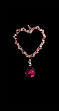 a heart shaped necklace with a pink stone