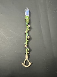 a piece of jewelry with green and blue beads on it