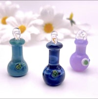 three small glass bottles with flowers on them