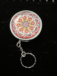 a circular keychain with a colorful design on it