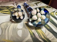 two blue and white glass pipes on a table