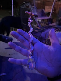 a person holding a crystal pendant in their hand