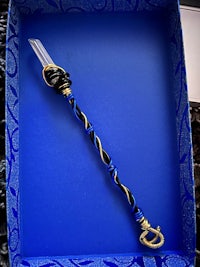 a blue and gold wand in a box