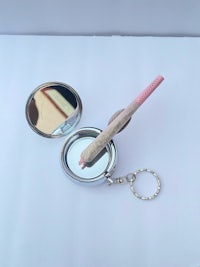 a key ring with a mirror and a pencil