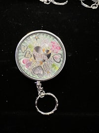 a key ring with a bird and flowers on it