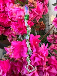 a pink flower with a green bead on it