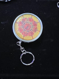 a keychain with a red and yellow flower on it