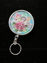 a key ring with a flower painted on it