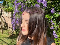 a woman wearing a purple headband in front of purple flowers