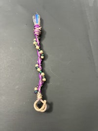 a purple wand with crystals and beads on it