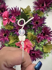 a person is holding a ring with a flower on it