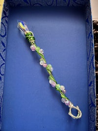 a blue box with a green and purple glass bead in it