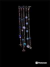 a group of beads hanging from a chain on a black background