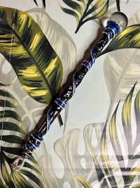 a black and blue pipe on a palm leaf