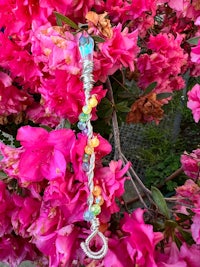 a pink flower with a bead on it