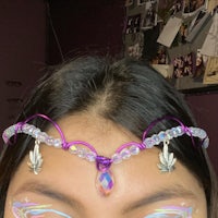 a woman wearing a purple headband with crystals on it