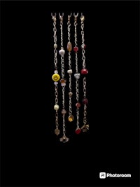 a group of beads hanging from a chain on a black background