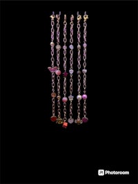 a group of necklaces hanging on a black background