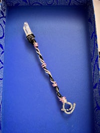 a blue box with a pink and white wand in it