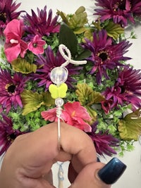 a person is holding a flower ring in front of flowers