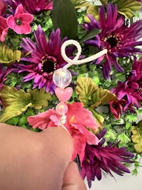 a person is putting a bead on a flower wreath